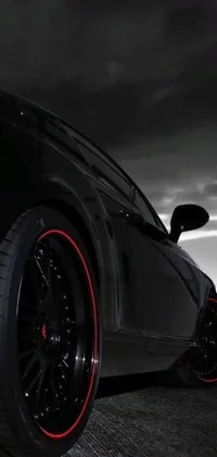 This dynamic phone live wallpaper displays a black car with striking red rims parked in an illuminated parking lot, set against an edgy smoky background