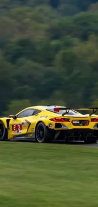 Get your engine revving with our epic live wallpaper featuring a yellow race car tearing up the tarmac on a state-of-the-art track