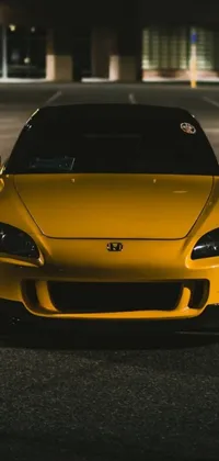 This phone live wallpaper depicts a yellow sports car parked in a modern parking lot
