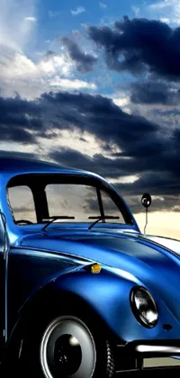 This stunning live wallpaper depicts a Blue VW Beetle parked under a cloudy sky at dusk