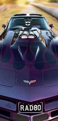 This phone live wallpaper showcases a stunning purple sports car driving down a winding road