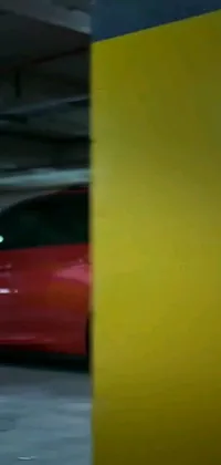 This phone live wallpaper features a stunning image by Karl Völker of a red sports car parked in an underground garage