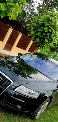 This dynamic phone live wallpaper features a sleek black Audi parked in front of a picturesque house