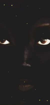 This phone live wallpaper displays a beautiful and mesmerizing close-up of an individual's eyes surrounded by darkness