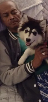 This live wallpaper showcases a serene and heartwarming scene of a man snuggled up in bed with his adorable husky dog