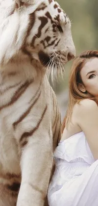 This live phone wallpaper depicts a stunning woman sitting next to a majestic white tiger