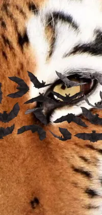 This phone live wallpaper showcases a breathtaking image of a tiger's eye, complete with bats perched on top