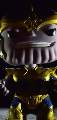 This live phone wallpaper is a close-up of a pop-art-inspired toy in Thanos armor, frowning and holding a golden chalice and miniature infinity gauntlet