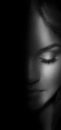 This stunning black and white live wallpaper features a glowing woman's face, half transformed with a silver light that shimmers and sparkles around her features