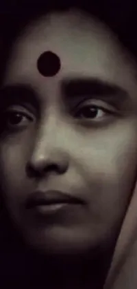 This live wallpaper depicts a powerful black and white image of a woman with a red dot on her forehead