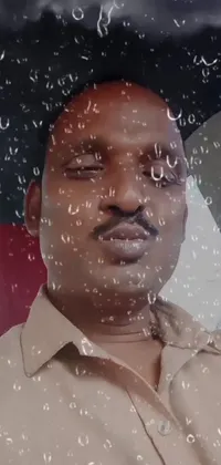 This phone live wallpaper features a man sitting inside a car as rain pours down around him