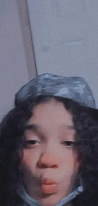 This phone live wallpaper captures a close-up image of a black teenage girl wearing a stylish hat