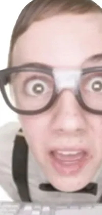This live phone wallpaper showcases a close-up of an individual with glasses, in a state of shock and awe, being surprised by something they have read or seen on their computer keyboard