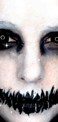This live phone wallpaper features a frighteningly close-up of a spooky face with a large black smile and white face paint