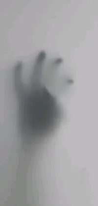This amazing phone live wallpaper features the eerie silhouette of a hand cast on a wall