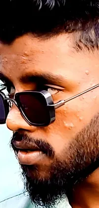 This smartphone live wallpaper showcases a close-up of a person sporting sunglasses, in a Sri Lankan Mad Max style