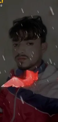 This amazing live wallpaper features a man wearing a striking red jacket and standing in the rain