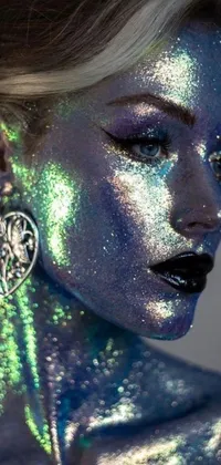 This holographic phone live wallpaper features a close-up of a glitter-covered woman in a metallic cyan bodysuit adorned with sparkling jewelry