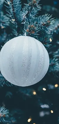 This Christmas tree live wallpaper features a close-up shot of a beautifully decorated tree with white and blue ornaments