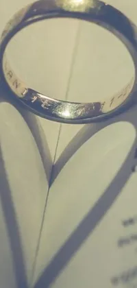 This live wallpaper features a stunning close up of a ring resting on a book