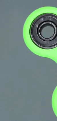 Looking for a mesmerizing live wallpaper? Check out this one! Featuring a colorful green fidget spinner that sits on a wooden table and spins rapidly in a range of directions, this live wallpaper is sure to catch your eye