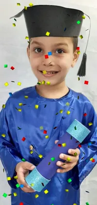 This live wallpaper depicts a blue graduation gown-wearing young boy holding his diploma with pride