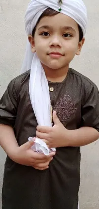 This phone live wallpaper showcases a young boy wearing a white turban and a brown outfit