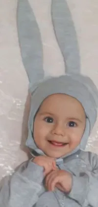 This live wallpaper depicts a close-up of a baby bunny wearing a cute grey wizard hat and holding a wand