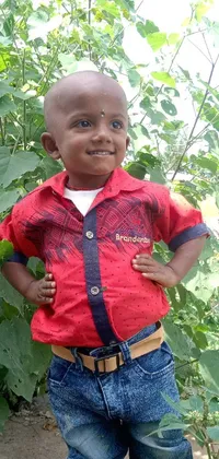 This phone live wallpaper features a little boy in a garden, with short white hair, wearing a bright yellow t-shirt and red shorts