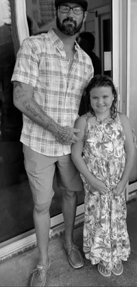 This phone live wallpaper depicts a touching black and white photograph of a man standing next to a little girl