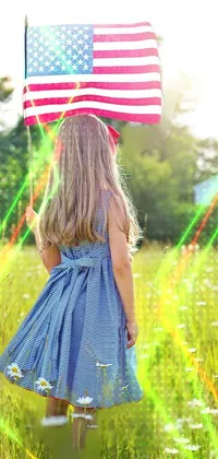 This captivating phone live wallpaper shows a lovely 5-year-old girl holding an American flag in a lush green field