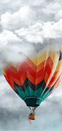 Enjoy the breathtaking sight of a hot air balloon flying high in a clear blue sky with this mesmerizing phone live wallpaper