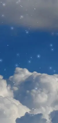 This phone live wallpaper features a breathtaking sky filled with numerous white clouds alongside shimmering stars that are spread throughout the wallpaper