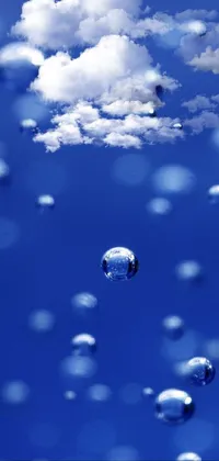 This live wallpaper features a stunning image of floating bubbles set against a breathtaking blue sky with fluffy clouds and dewdrops on the grass