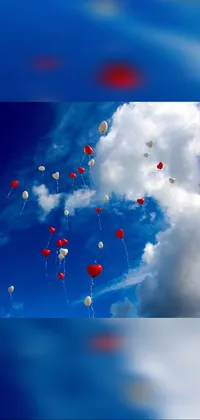 This lively phone live wallpaper features a delightful scene of red and white balloons flying high up in the sky against a charming blue and red polka dot backdrop