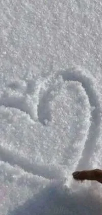 This phone live wallpaper is a lovely depiction of a heart being drawn in the snow