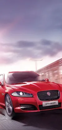 Experience the thrill of driving a luxurious red Jaguar XF IQ4 with this stunning phone live wallpaper! The sleek design is captured in flawless detail, using side lighting to accentuate every curve and angle