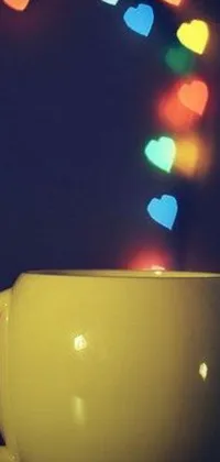 This charming phone live wallpaper features a yellow cup filled with hearts floating out of it