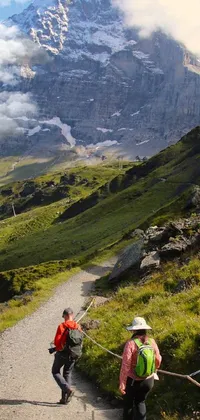 This phone live wallpaper features a serene and peaceful scene of a couple taking a walk on a beautiful trail in the Lauterbrunnen Valley