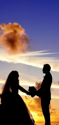 This stunning phone live wallpaper showcases a beautiful silhouette of a bride and groom holding hands against a breathtaking sky setting