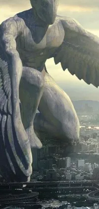 This phone live wallpaper features a magnificent angel statue atop a building, set against a stunning cityscape backdrop