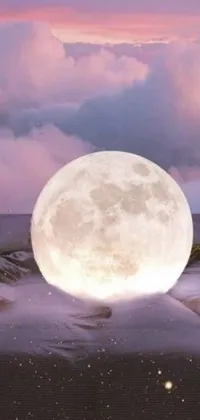 This live phone wallpaper showcases a beautiful digital rendering of a sandy beach with a giant pink full moon hovering above it