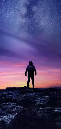 This live wallpaper for your phone showcases a stunning digital art image of a spaceman standing on a rock under a sky full of twinkling stars