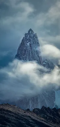 This phone live wallpaper showcases a captivating portrait of a snow-covered mountain on a cloudy day