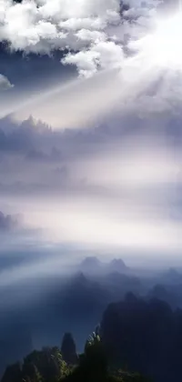 This phone live wallpaper showcases a breathtaking mountain top scene, with sunbeams shining down on a group of people