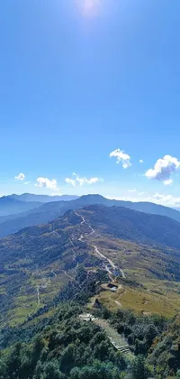 Experience the beauty of Sichuan's majestic mountains with this stunning live wallpaper! The clear blue sky and winding road between rolling hills create a serene and peaceful atmosphere
