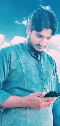 This live wallpaper showcases a man gazing at his phone in a low angle shot, set against a sky background