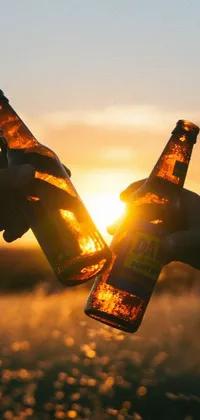 Looking for an eye-catching mobile live wallpaper to give your device a fresh new look? Check out this stunning design featuring two people holding beer bottles against a beautiful sunset backdrop
