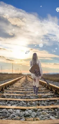 This mesmerizing live phone wallpaper depicts a woman strolling down a railroad track at sunset