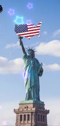This phone live wallpaper depicts the Statue of Liberty holding an American flag against a cloudy sky backdrop
